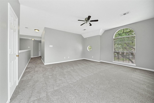 carpeted spare room featuring ceiling fan and vaulted ceiling