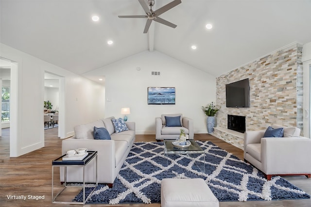 living room featuring hardwood / wood-style flooring, vaulted ceiling with beams, ceiling fan, and a fireplace