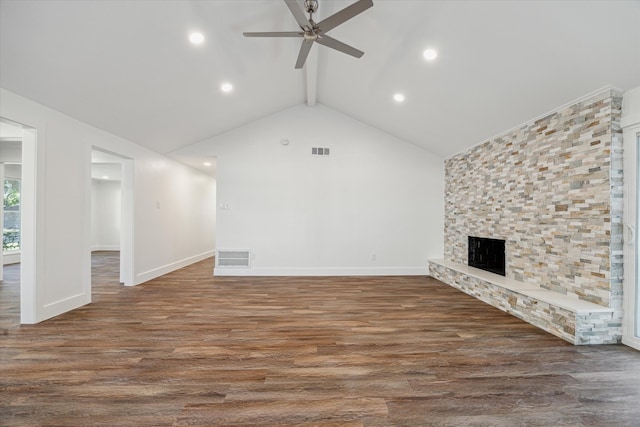 unfurnished living room featuring ceiling fan, high vaulted ceiling, beamed ceiling, dark hardwood / wood-style floors, and a stone fireplace