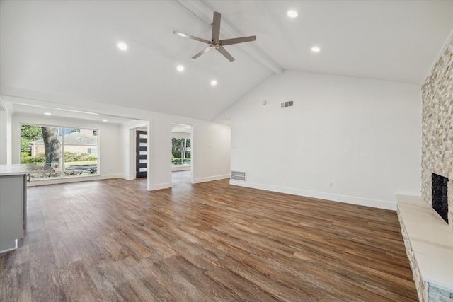 unfurnished living room featuring ceiling fan, dark hardwood / wood-style flooring, beamed ceiling, high vaulted ceiling, and a fireplace