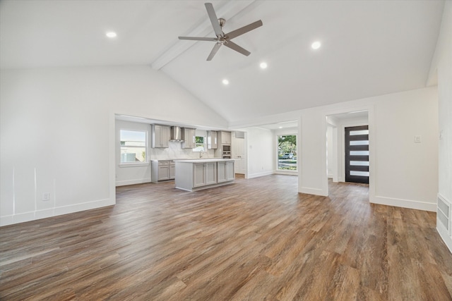 unfurnished living room featuring hardwood / wood-style floors, ceiling fan, beamed ceiling, and high vaulted ceiling