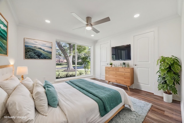 bedroom featuring dark hardwood / wood-style floors, ceiling fan, and crown molding