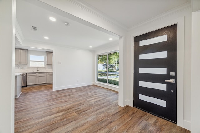 foyer featuring sink, hardwood / wood-style floors, and ornamental molding