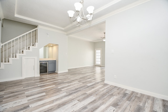 unfurnished living room featuring ceiling fan with notable chandelier, light hardwood / wood-style floors, beverage cooler, and crown molding