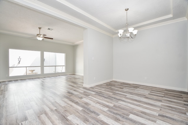 spare room with ceiling fan with notable chandelier, light hardwood / wood-style floors, a raised ceiling, and crown molding