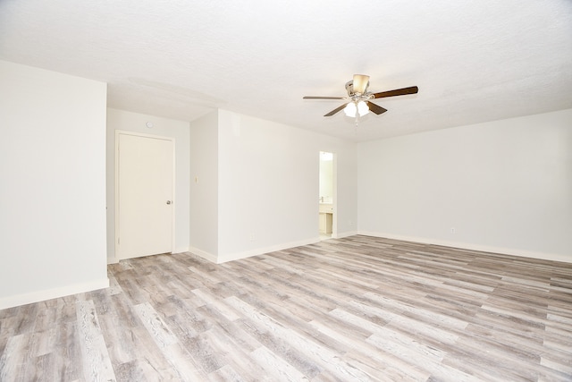 spare room featuring ceiling fan, light hardwood / wood-style floors, and a textured ceiling