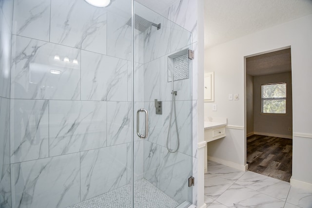 bathroom featuring a shower with door, vanity, hardwood / wood-style floors, and a textured ceiling