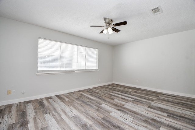 spare room with ceiling fan, hardwood / wood-style floors, and a textured ceiling