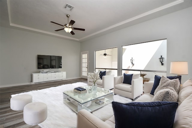 living room with hardwood / wood-style flooring, ceiling fan, and a raised ceiling