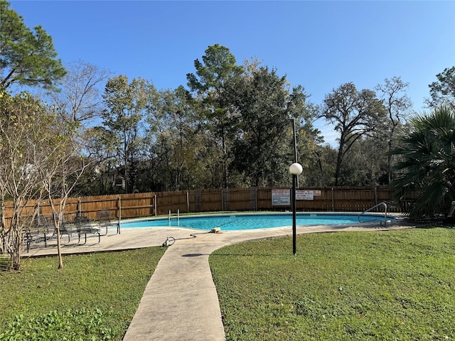 view of pool with a lawn