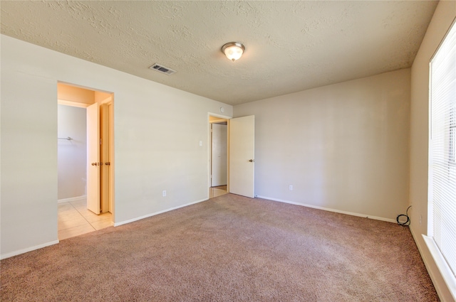 carpeted empty room featuring a textured ceiling