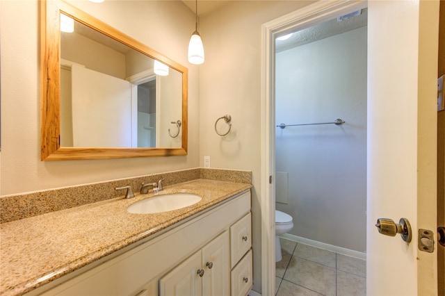 bathroom with tile patterned flooring, vanity, and toilet