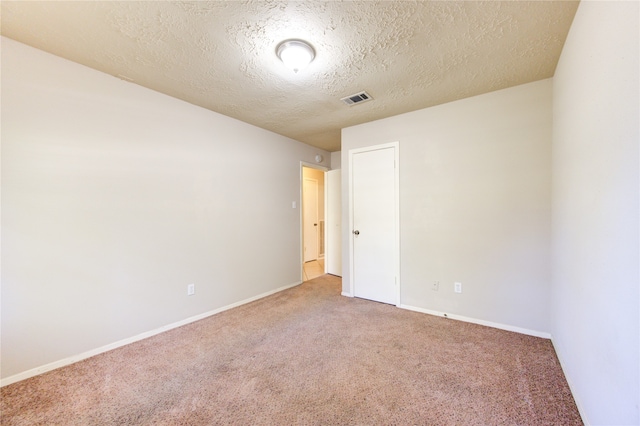 carpeted empty room with a textured ceiling