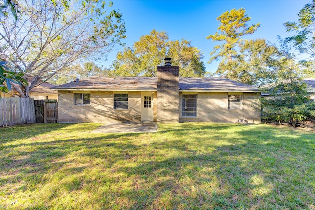 rear view of house with a yard and a patio