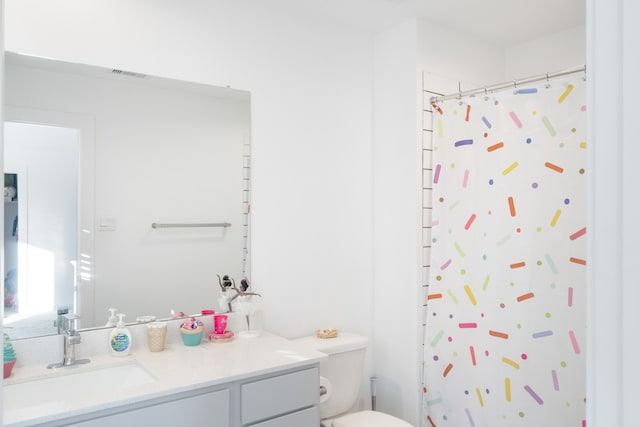 bathroom with toilet, vanity, and a shower with curtain