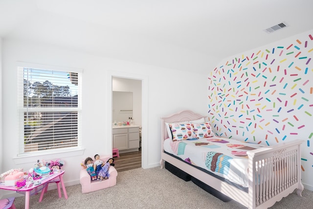 bedroom with light colored carpet, ensuite bathroom, and vaulted ceiling