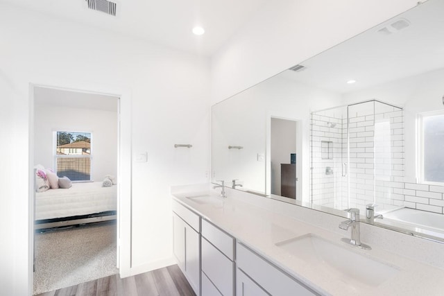 bathroom with hardwood / wood-style floors, walk in shower, and vanity