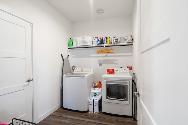 clothes washing area with dark hardwood / wood-style floors and separate washer and dryer