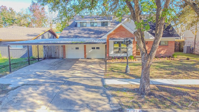 view of front of property featuring cooling unit, a garage, and a front yard