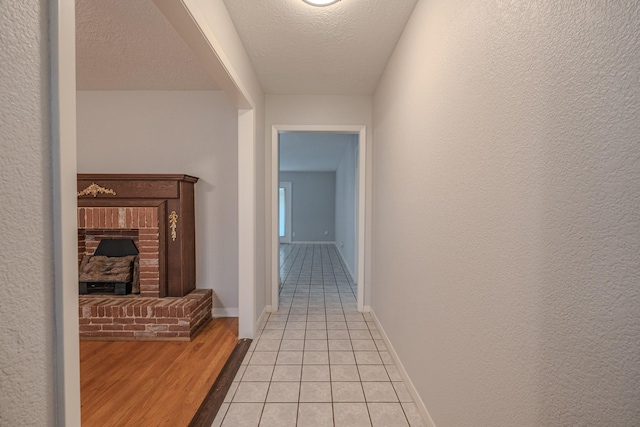 hallway featuring a textured ceiling and light hardwood / wood-style floors