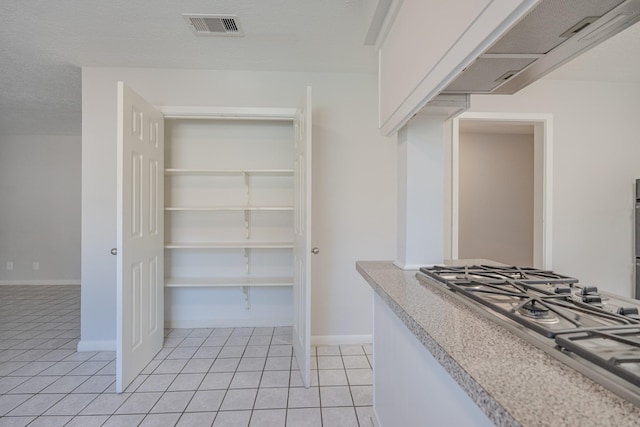 spacious closet with light tile patterned floors