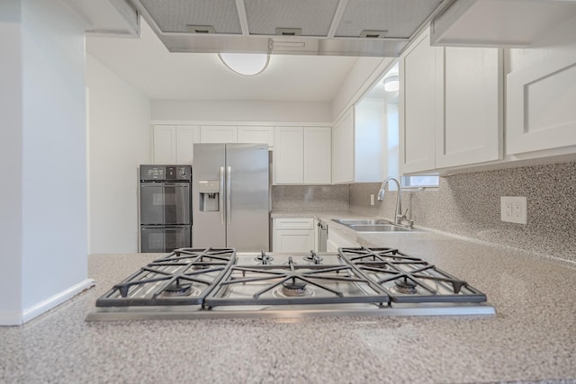 kitchen featuring decorative backsplash, stainless steel appliances, white cabinetry, and sink