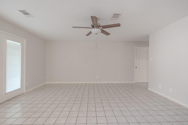 tiled spare room featuring ceiling fan and a textured ceiling