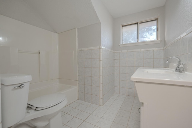 bathroom featuring lofted ceiling, tile patterned flooring, tile walls, and toilet