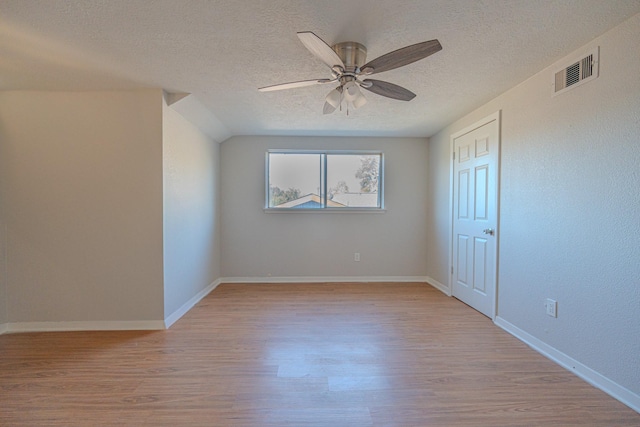 unfurnished bedroom featuring ceiling fan, a textured ceiling, and light wood-type flooring