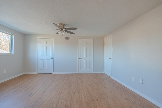 unfurnished bedroom with ceiling fan, a textured ceiling, and light hardwood / wood-style flooring