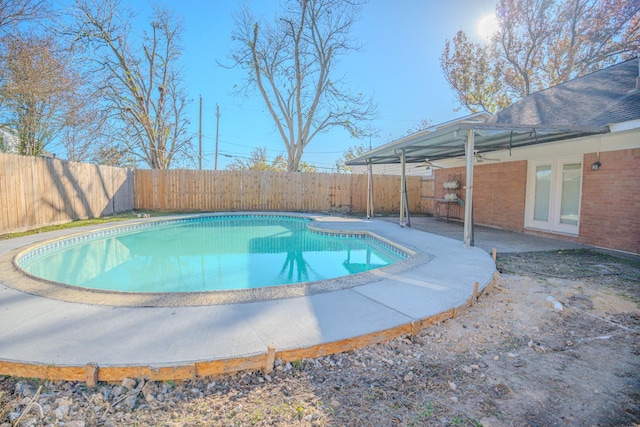 view of swimming pool featuring ceiling fan and a patio