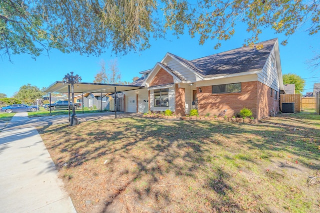 view of front of home with a front lawn, a carport, and cooling unit