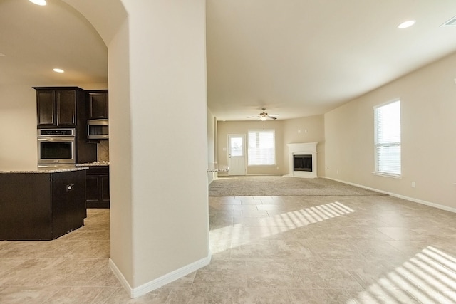 unfurnished living room featuring ceiling fan and light tile patterned floors