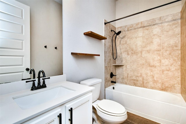 full bathroom featuring tiled shower / bath combo, vanity, wood-type flooring, and toilet