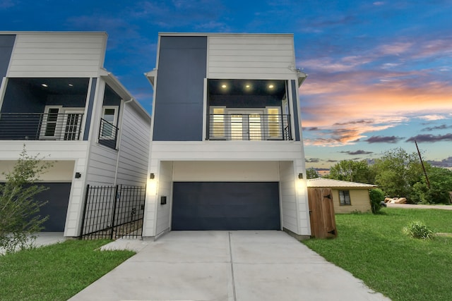 contemporary home featuring a yard, a balcony, and a garage