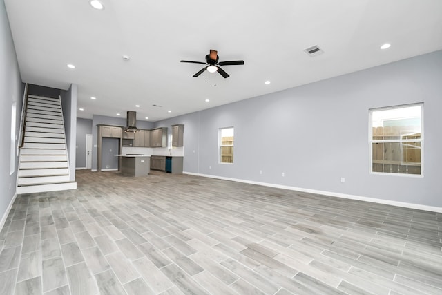 unfurnished living room featuring ceiling fan and light hardwood / wood-style floors