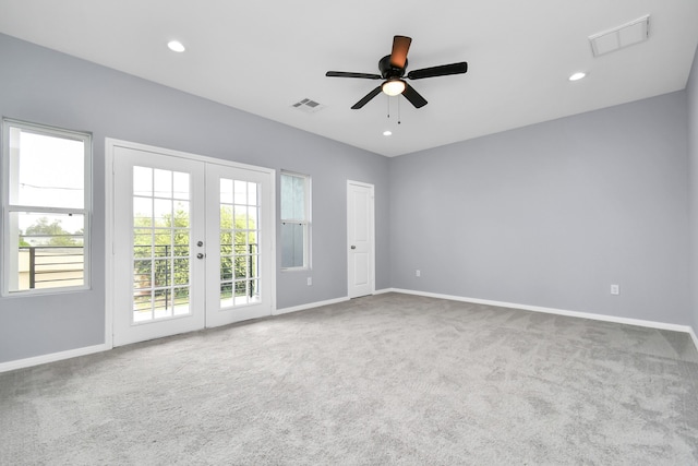 carpeted spare room featuring ceiling fan and french doors