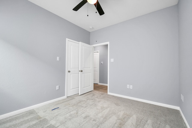 unfurnished bedroom with light colored carpet and ceiling fan