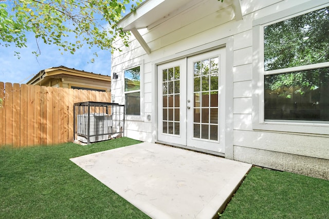 entrance to property featuring a yard, french doors, and a patio