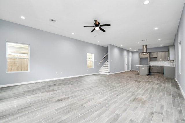 unfurnished living room with light hardwood / wood-style floors, plenty of natural light, and ceiling fan