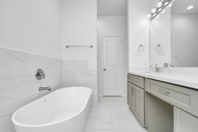 bathroom featuring vanity, a bath, and tile walls