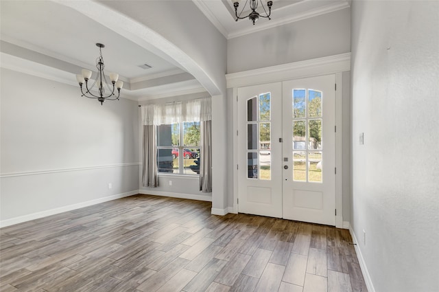 entryway with hardwood / wood-style floors, an inviting chandelier, french doors, and crown molding