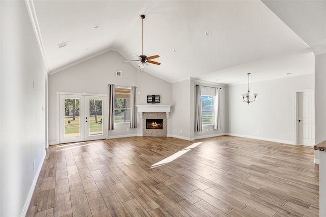 unfurnished living room with light hardwood / wood-style flooring, high vaulted ceiling, ceiling fan with notable chandelier, and ornamental molding