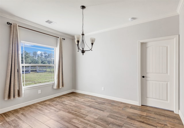 unfurnished dining area featuring wood-type flooring, crown molding, and a chandelier