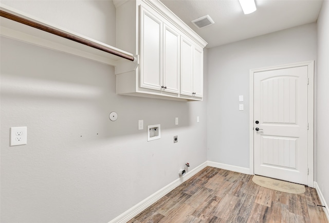 laundry room with electric dryer hookup, gas dryer hookup, cabinets, hardwood / wood-style flooring, and washer hookup