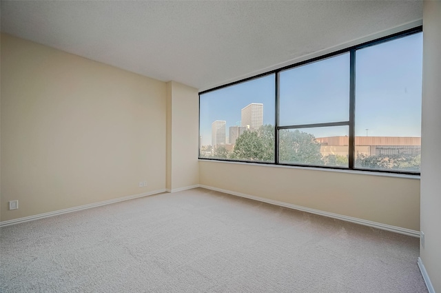 carpeted empty room featuring a textured ceiling