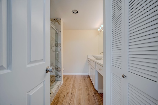 bathroom with a tile shower, vanity, and hardwood / wood-style flooring