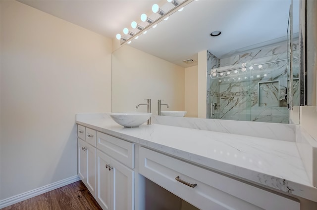 bathroom with hardwood / wood-style flooring, vanity, and a shower with shower door