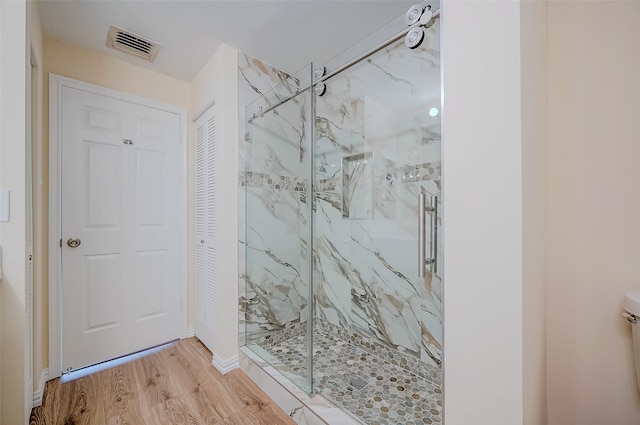 bathroom with hardwood / wood-style flooring and an enclosed shower