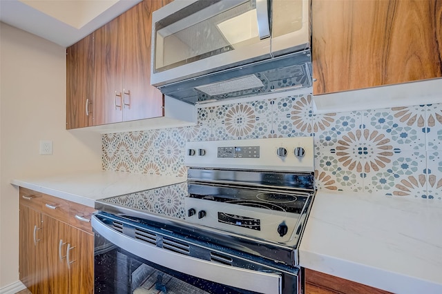 kitchen with stainless steel appliances and tasteful backsplash